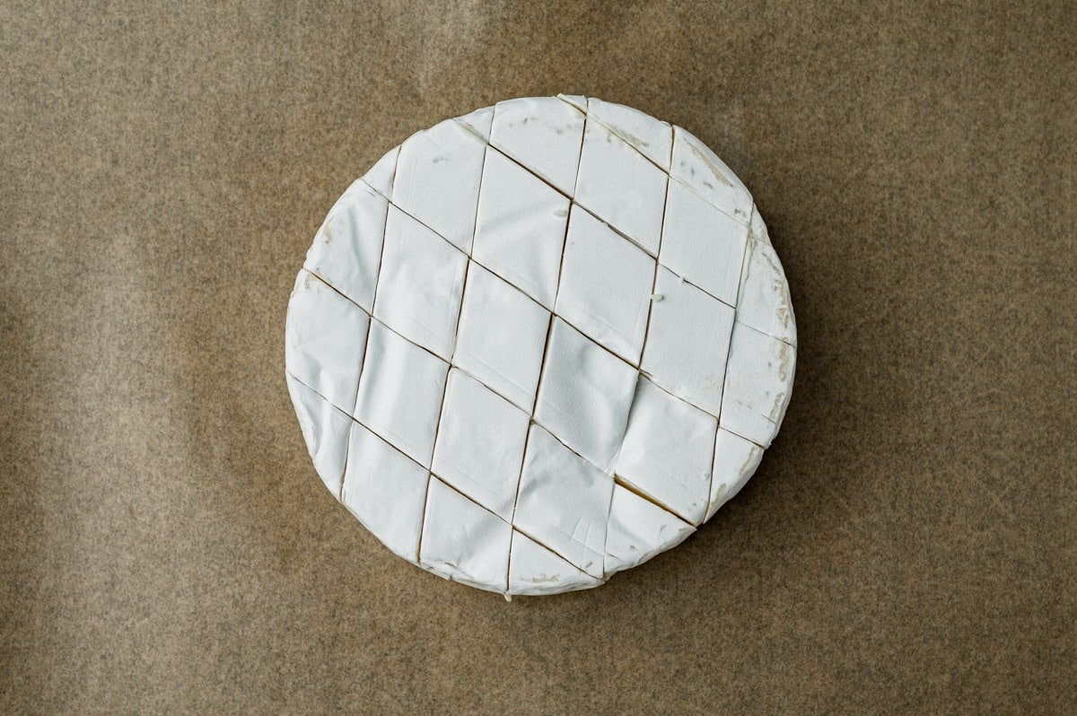 a wheel of brie with cuts in the top