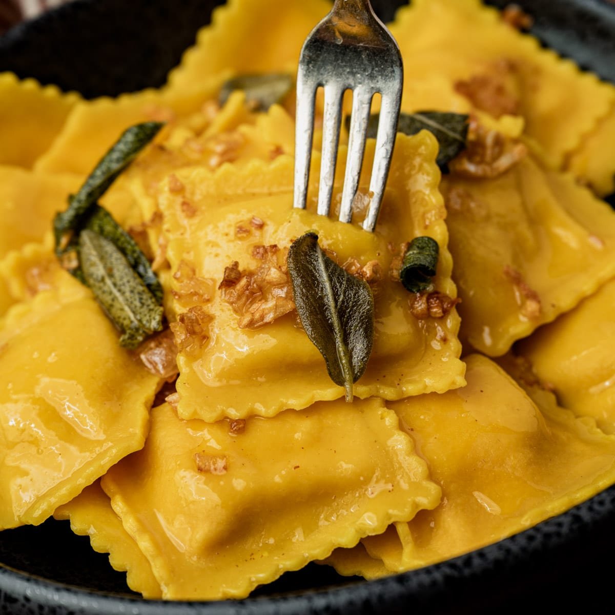 closeup of ravioli with sage butter sauce