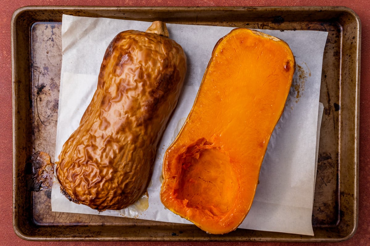 butternut squash cut in half on a baking sheet