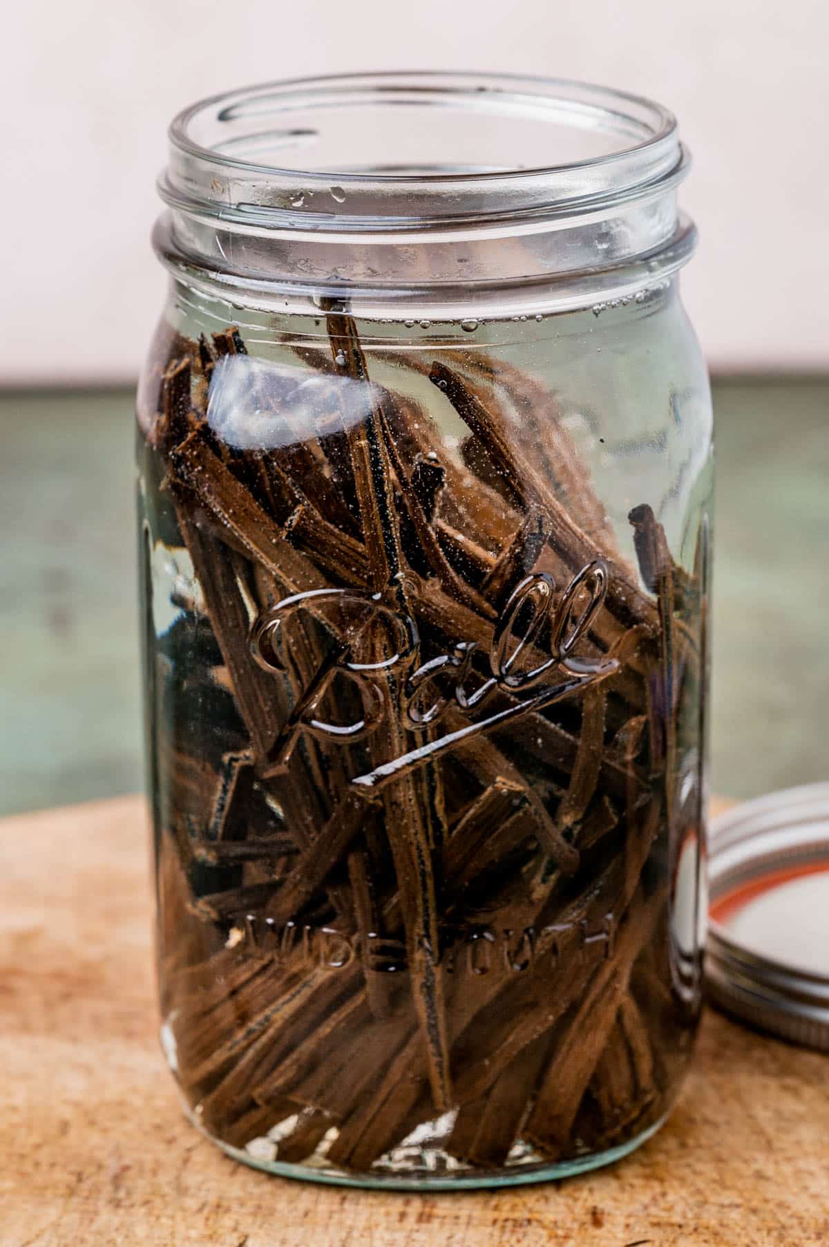 a mason jar full of vodka and vanilla beans