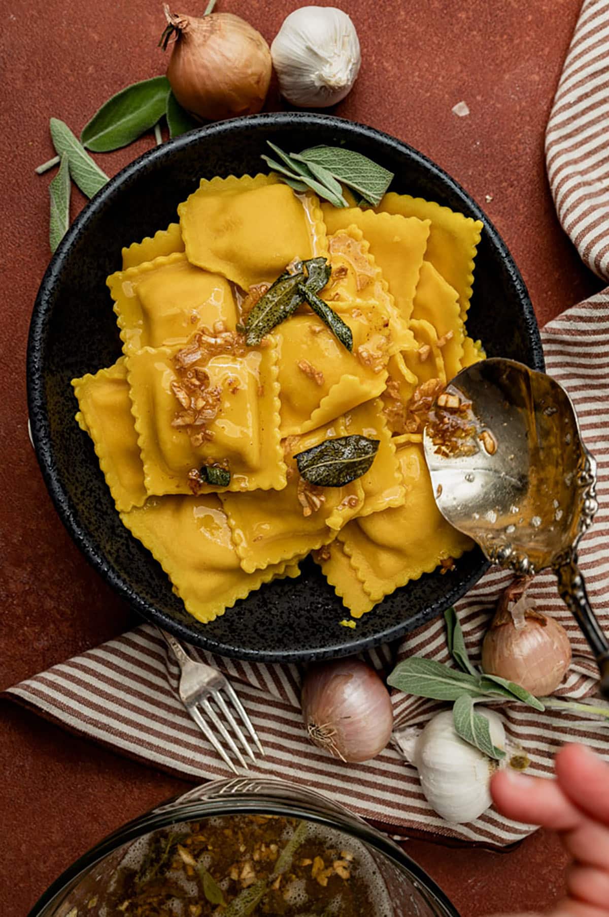 Overhead view of sage butter sauce over butternut squash ravioli