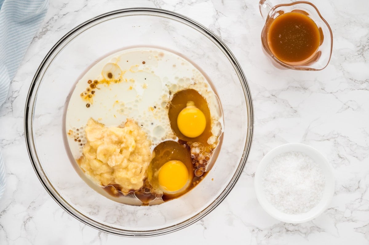 eggs, milk, vanilla and bananas in a bowl