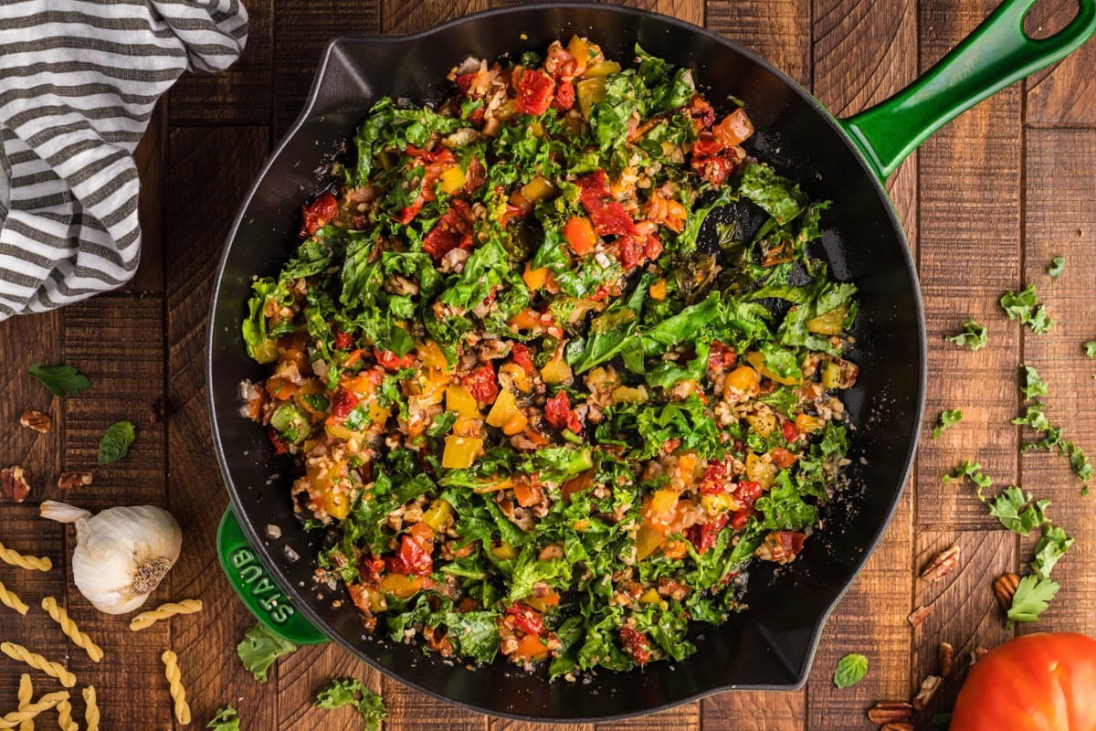 kale, peppers, tomato and pecan in a skillet