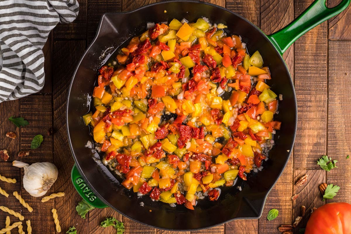 Sautéed tomatoes, pecans and peppers in a skillet