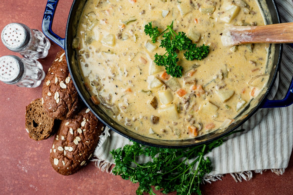 a pot of cheeseburger soup with parsley on top