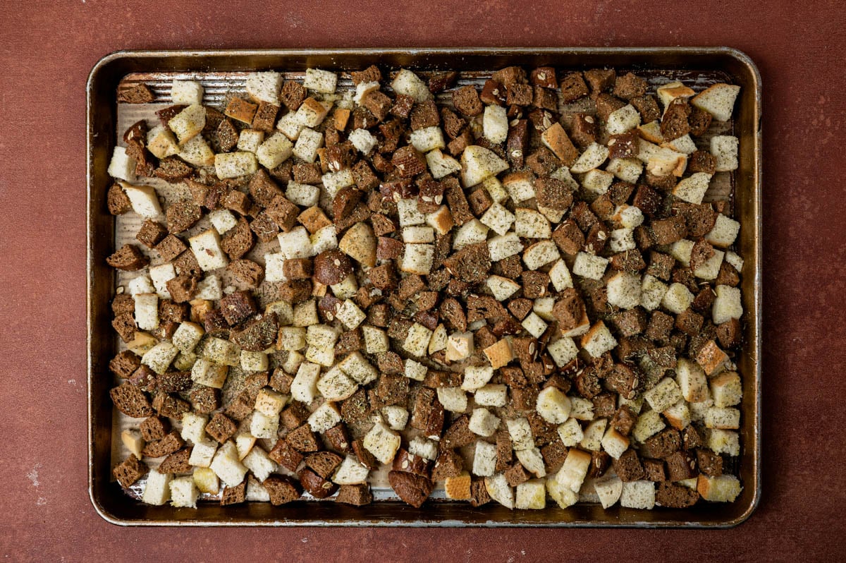 seasoned bread cubes sitting on a baking sheet