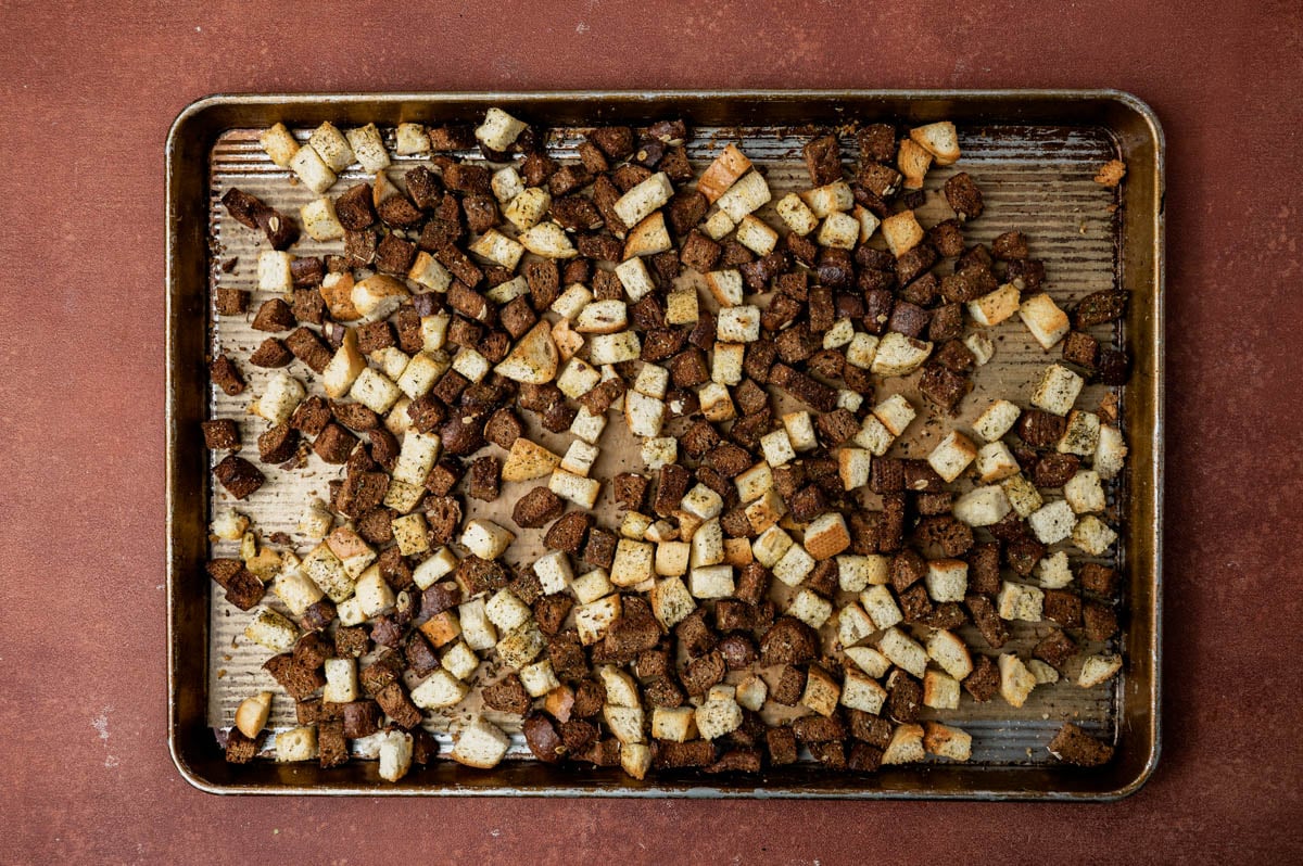 homemade croutons sitting on a baking sheet