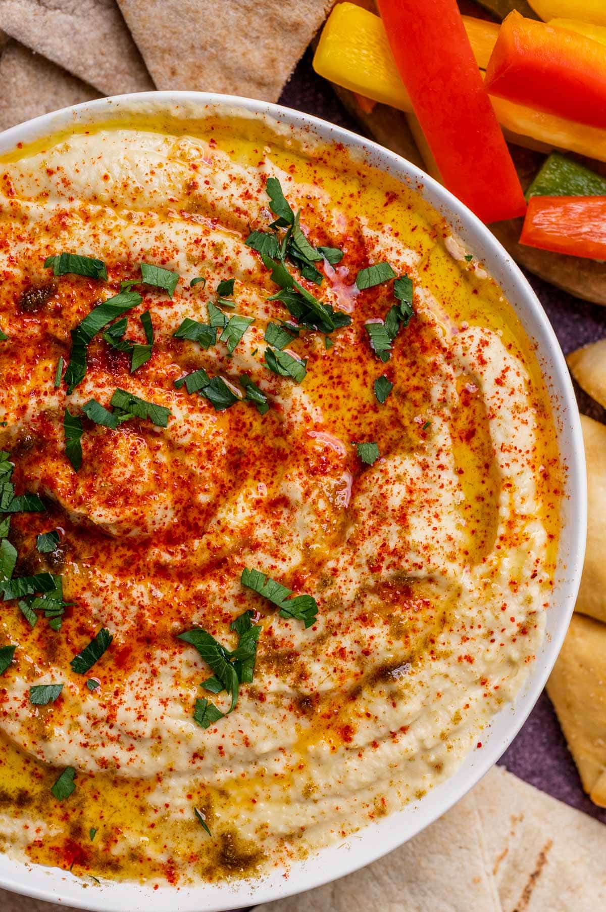 a bowl of hummus with parsley, cumin and paprika