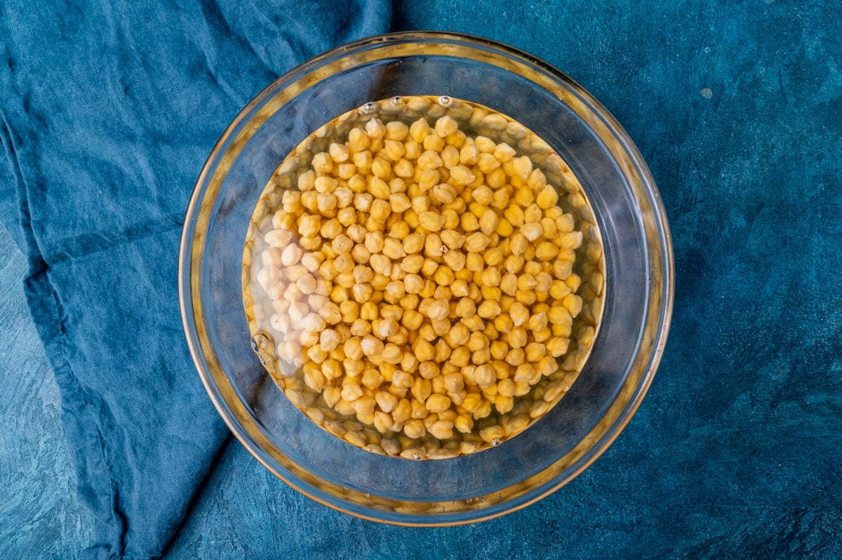 garbanzo beans soaking in a bowl of water