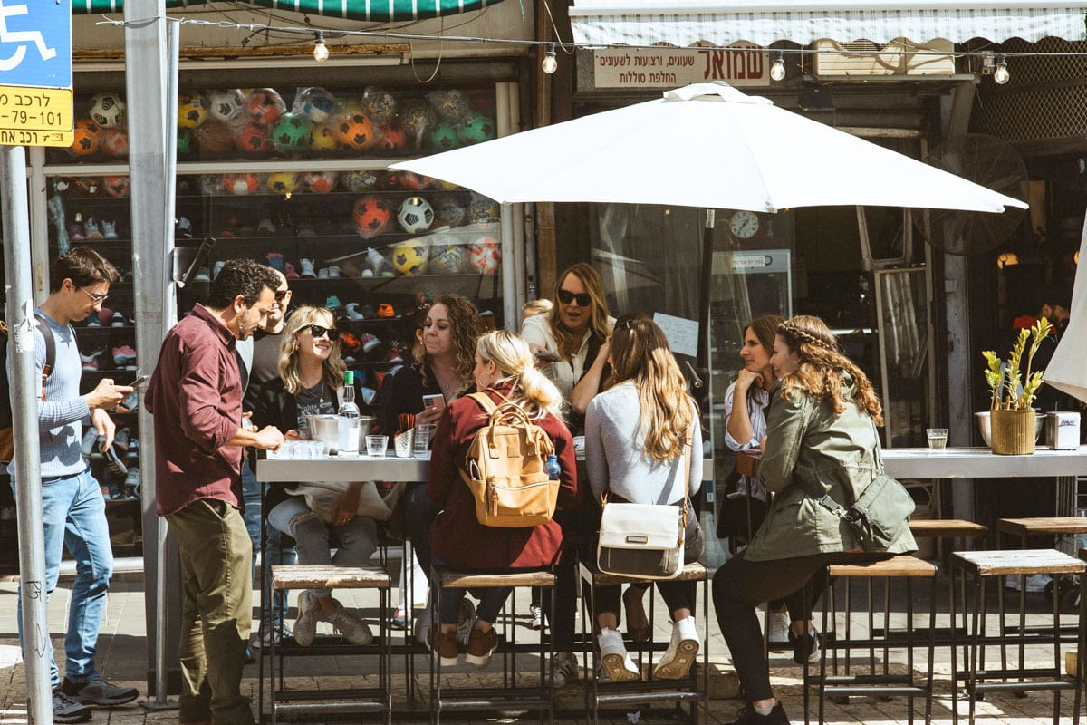 girls sitting around a patio table outside a restaurant