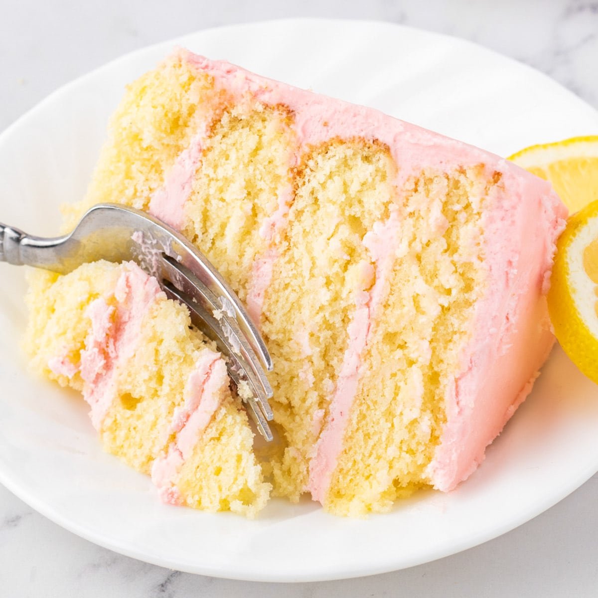 a slice of lemon raspberry cake on a plate with a fork