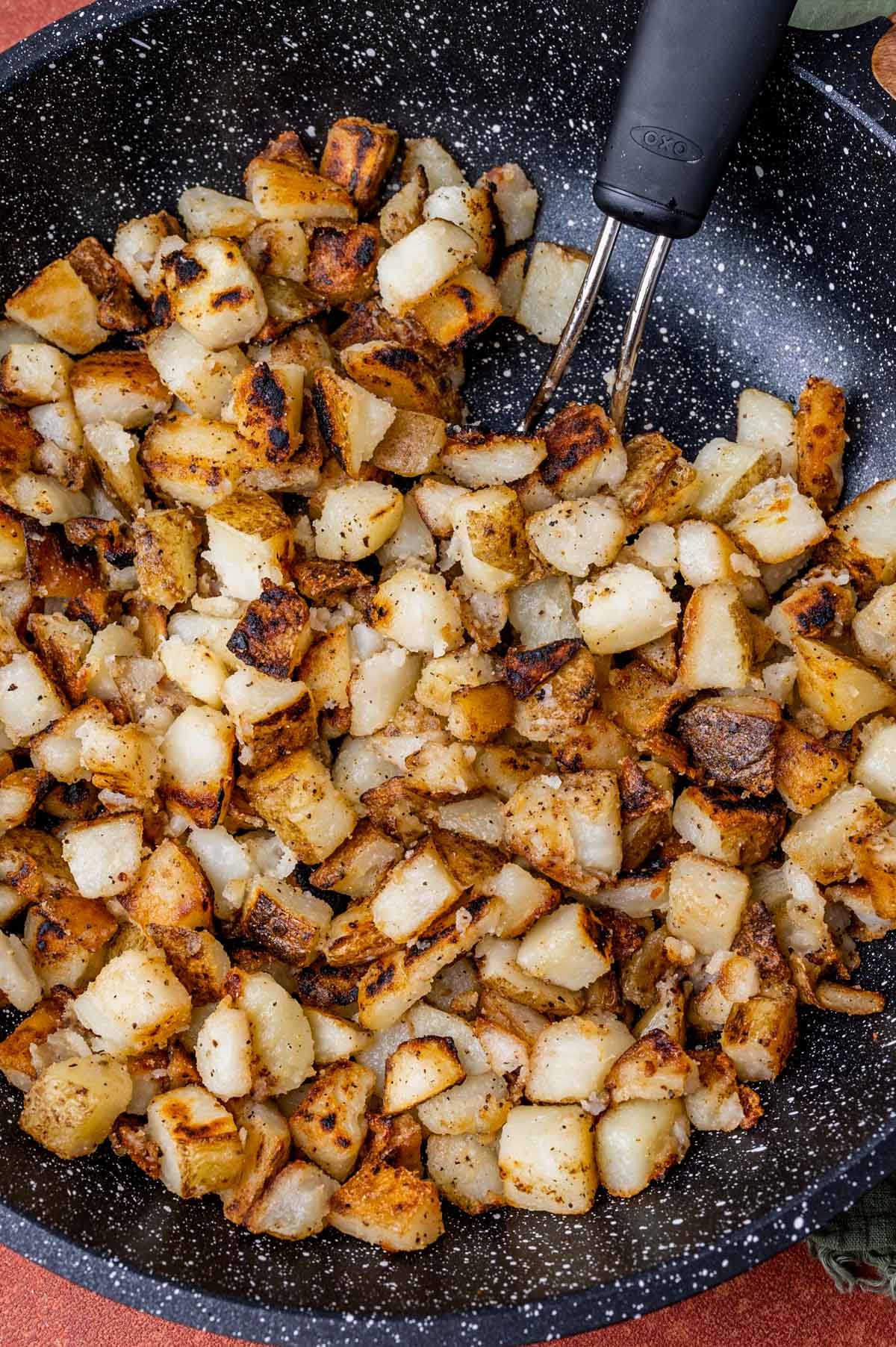 home fried potatoes in a skillet with a spatula