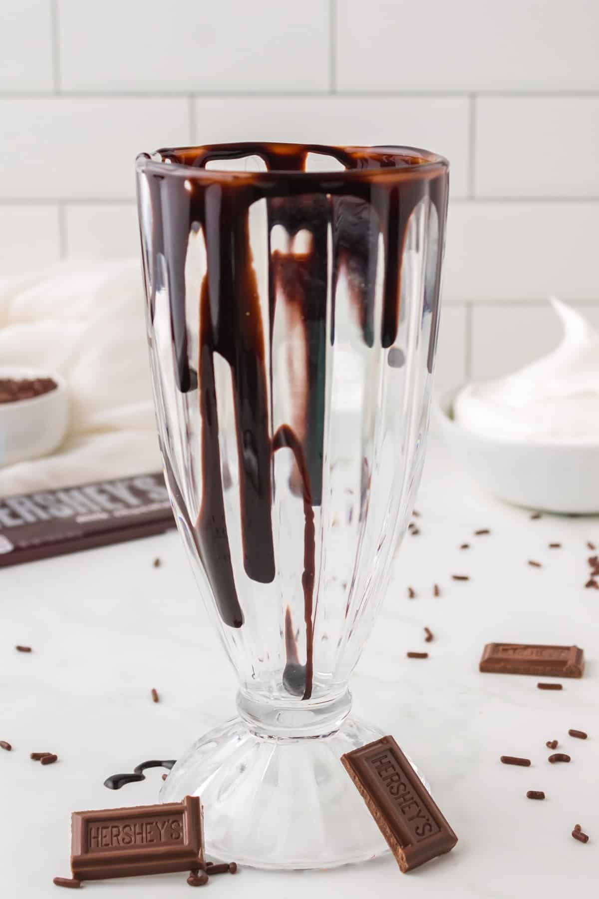 a milkshake glass drizzled with chocolate syrup