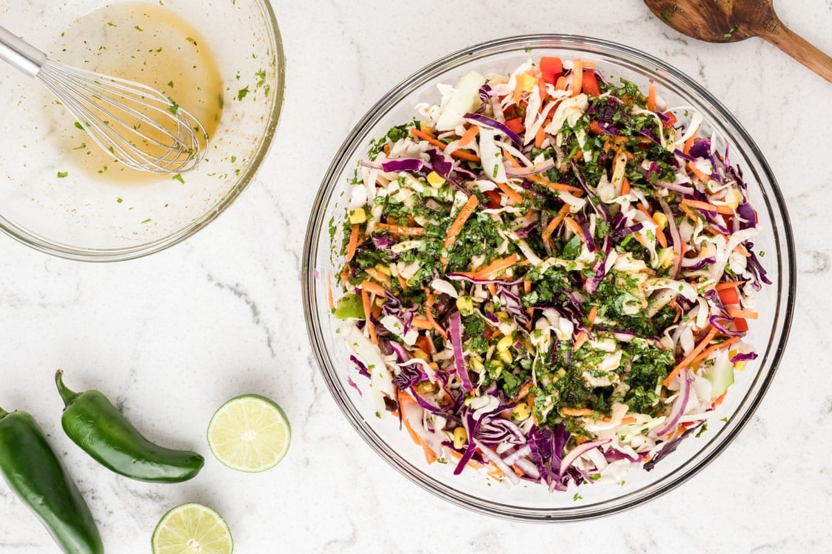 a bowl of Mexican coleslaw with dressing poured over the top