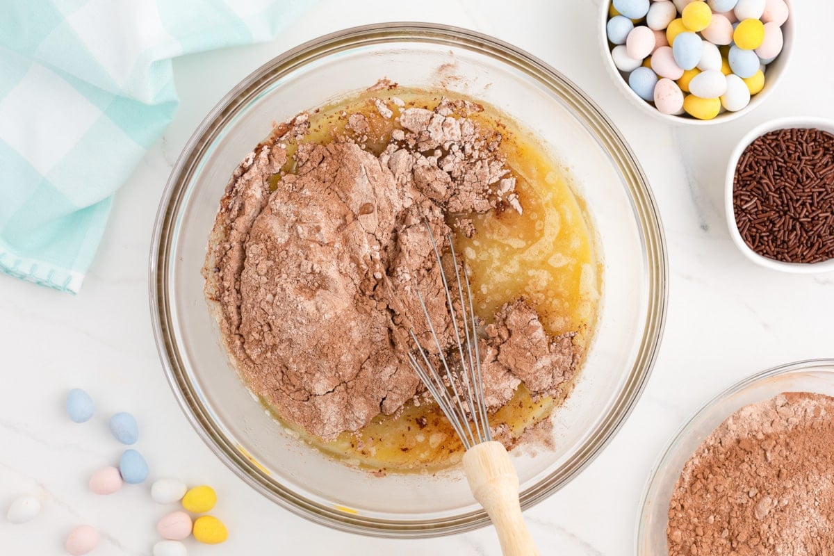 dry ingredients over wet ingredients in a glass bowl with a whisk