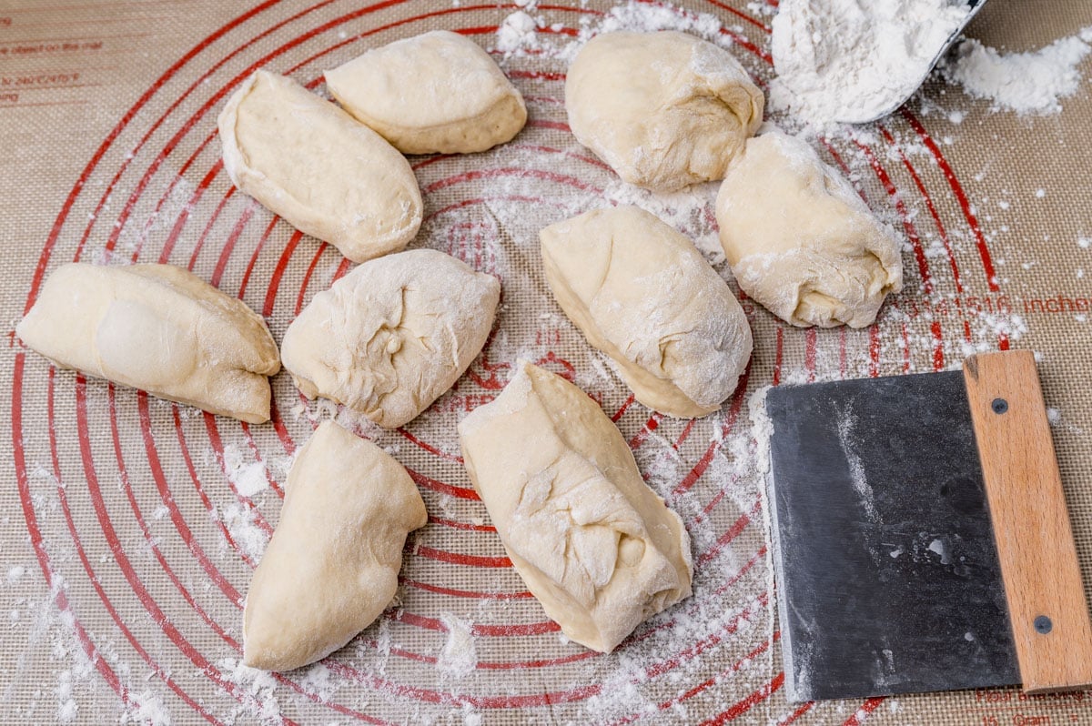 pieces of dough and a dough cutter on a pastry mat