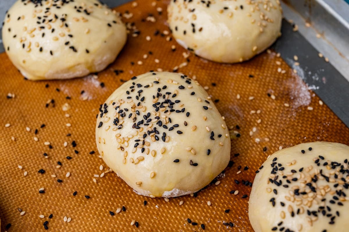 unbaked sourdough rolls on a baking sheet