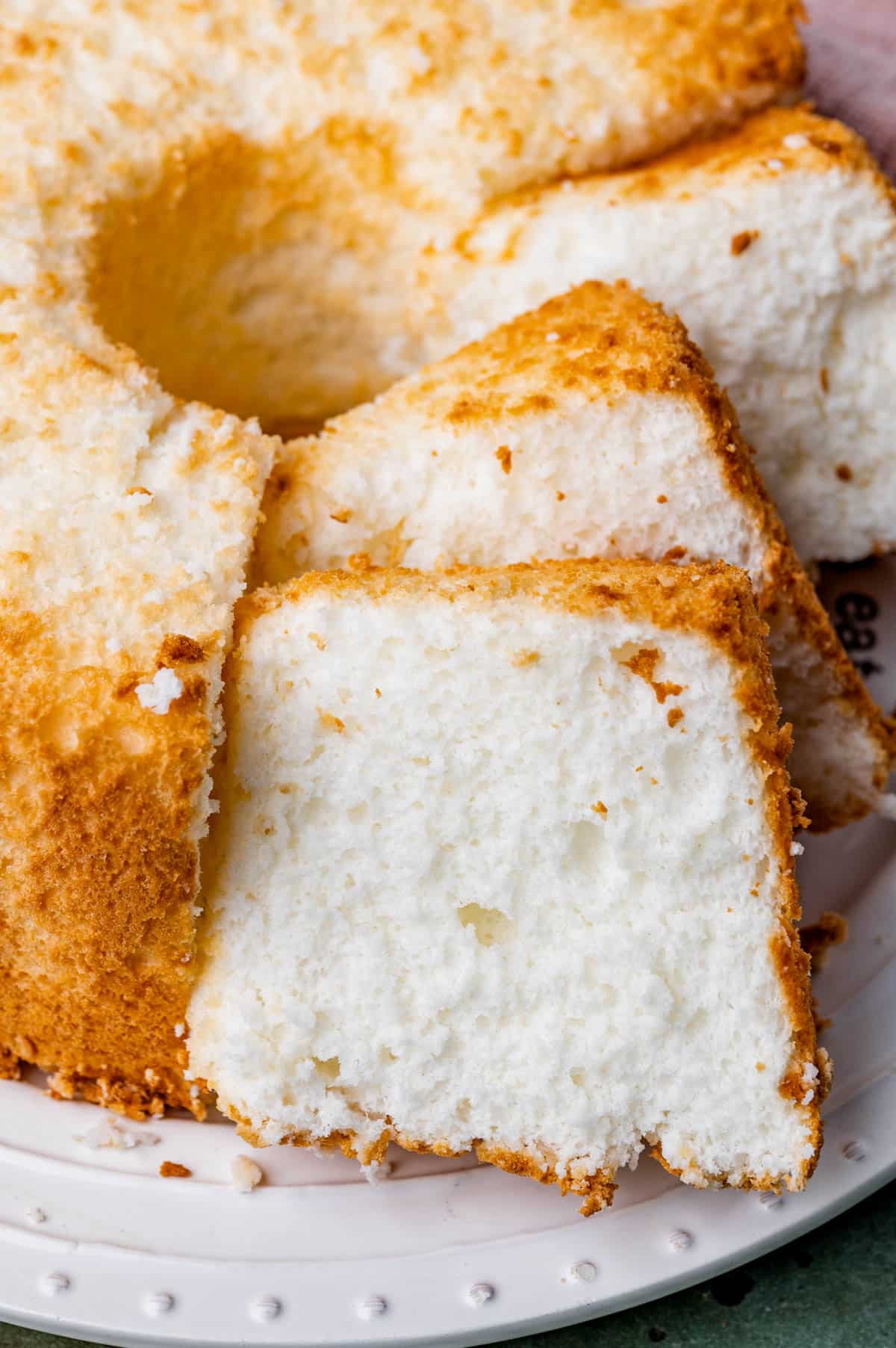 an angel food cake on a plate with half cut in slices