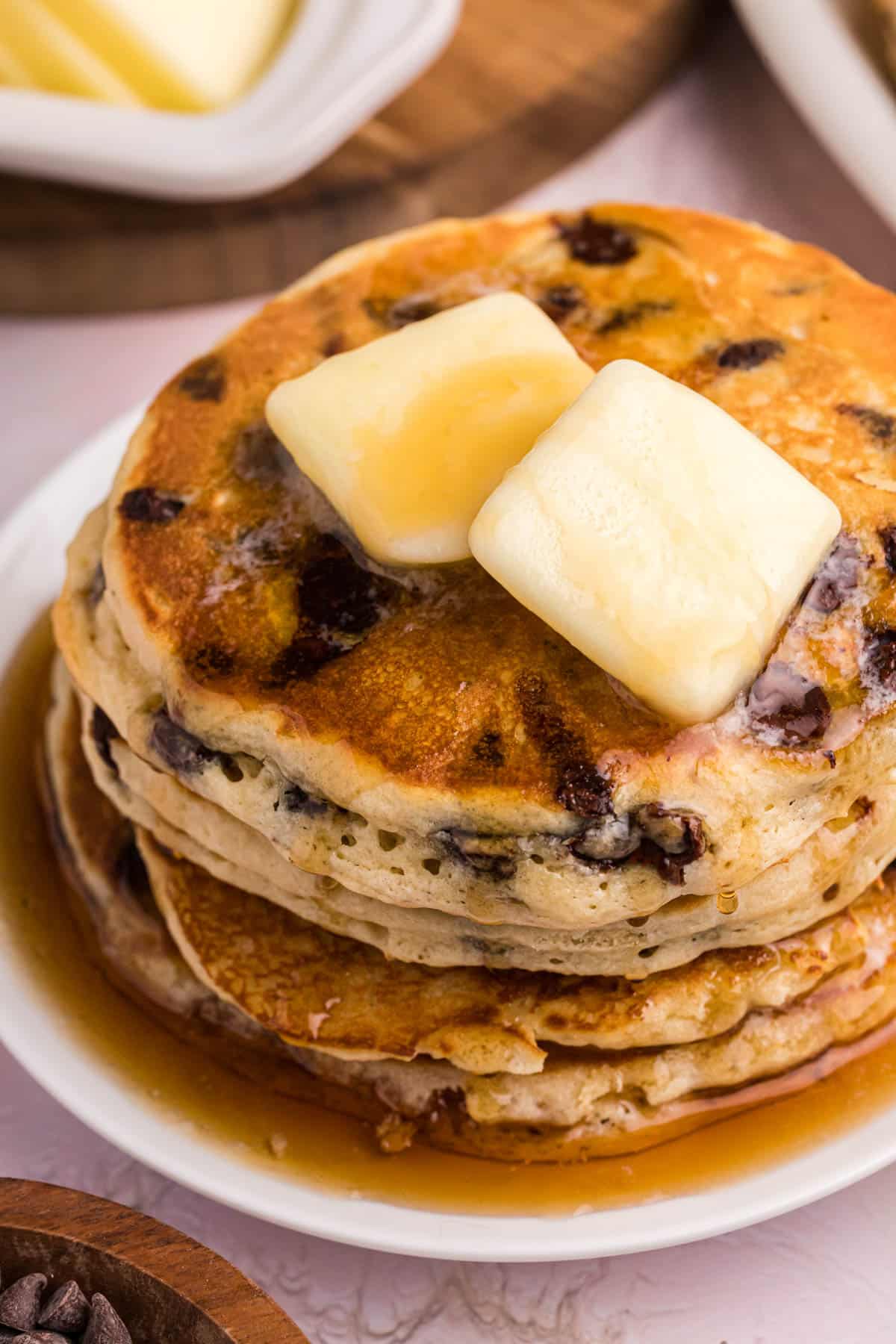 a stack of pancakes with syrup and butter