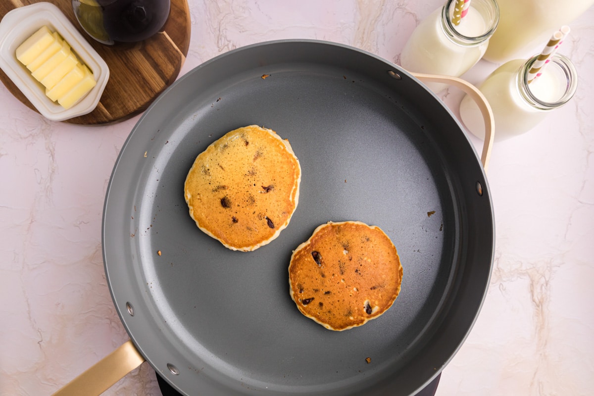 two chocolate chip pancakes in a pan