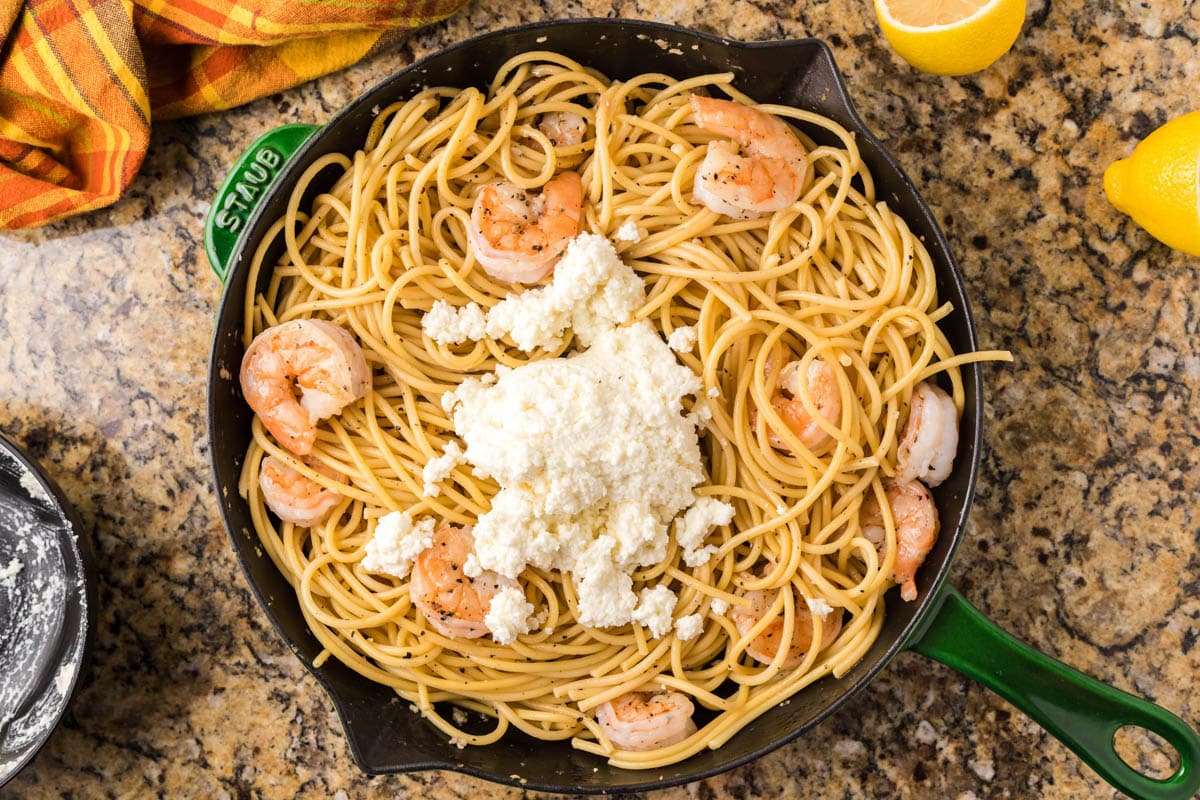 spaghetti and shrimp with parmesan cheese on top