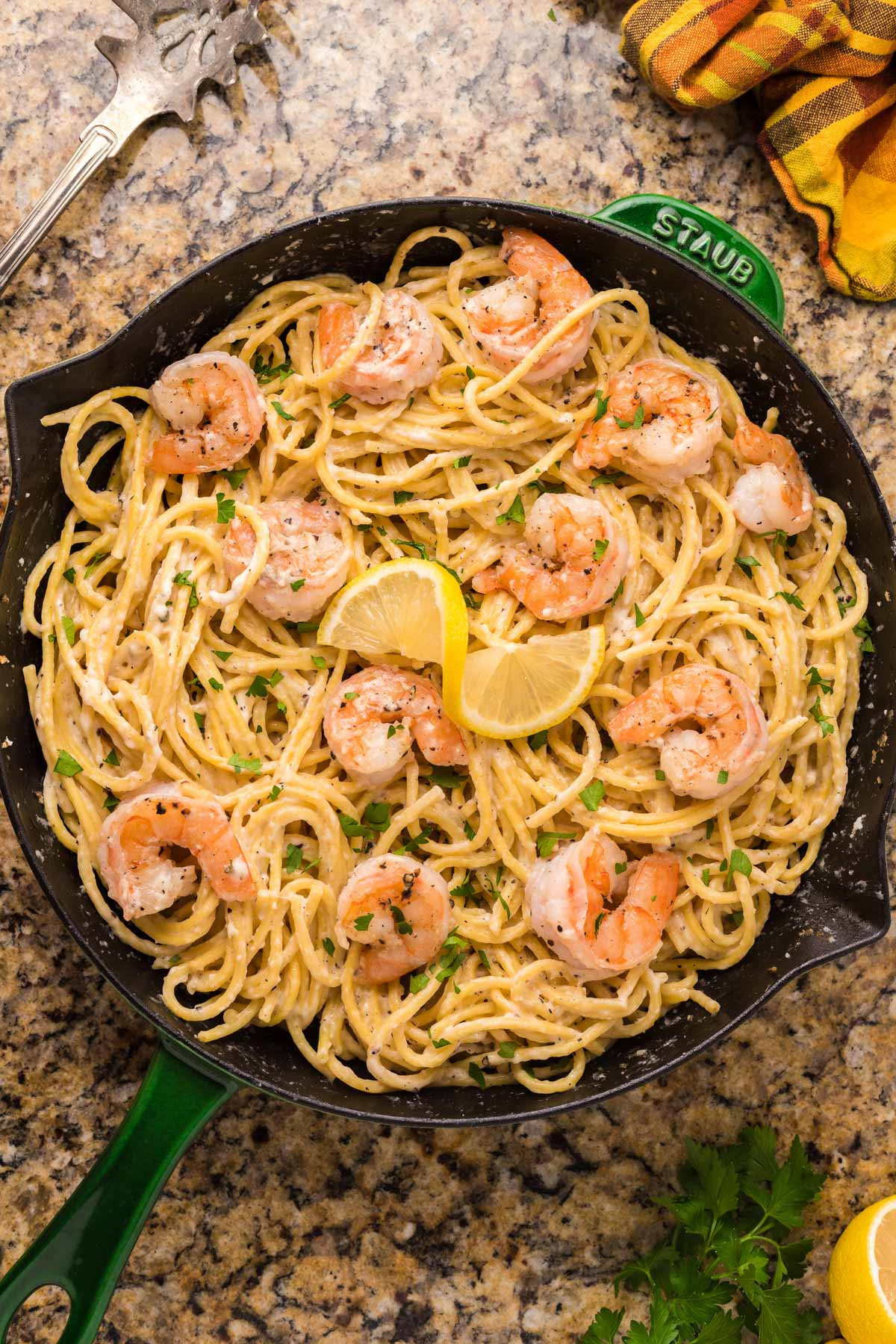 a skillet sitting on a table with shrimp pasta in it
