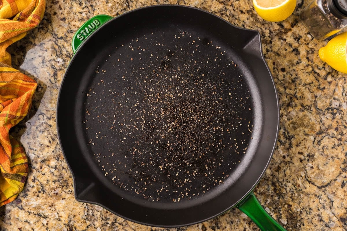 skillet with oil and cracked black pepper