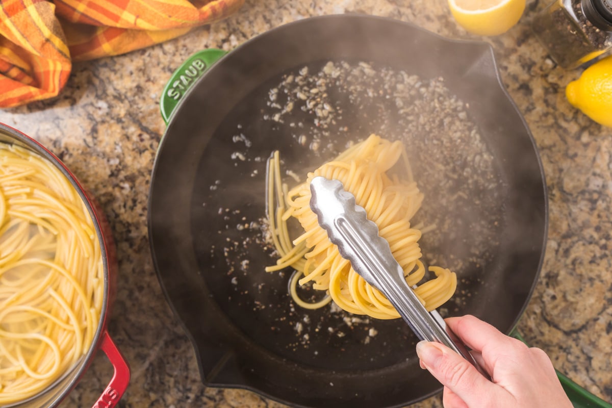 adding spaghetti to a hot skillet