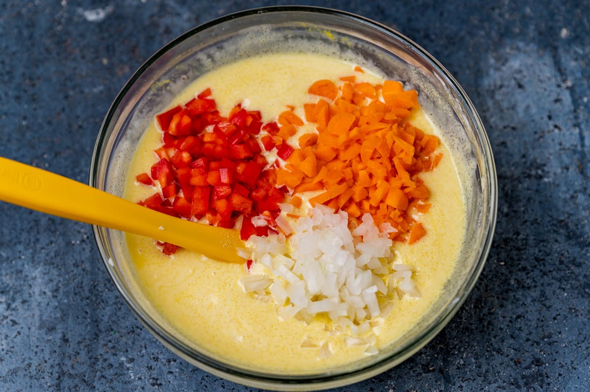 macaroni salad dressing in a bowl with red pepper, carrots and onions