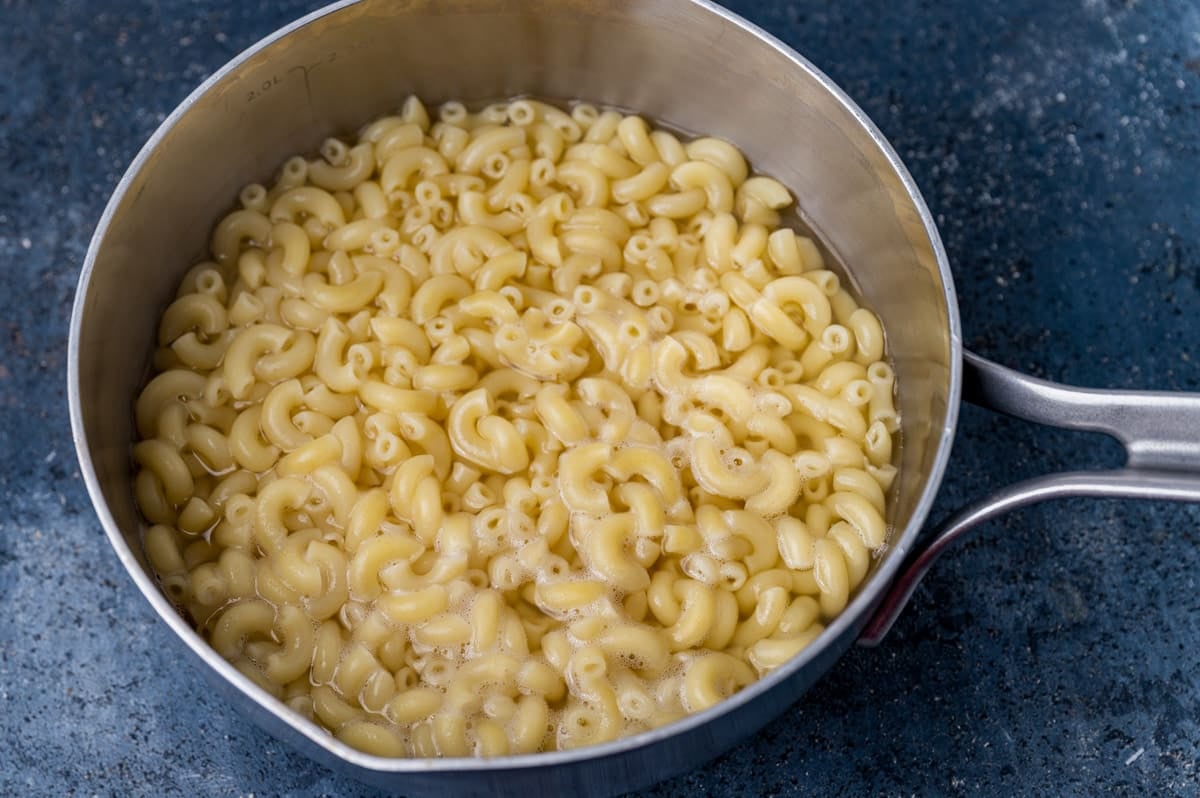 elbow macaroni in water in a saucepan