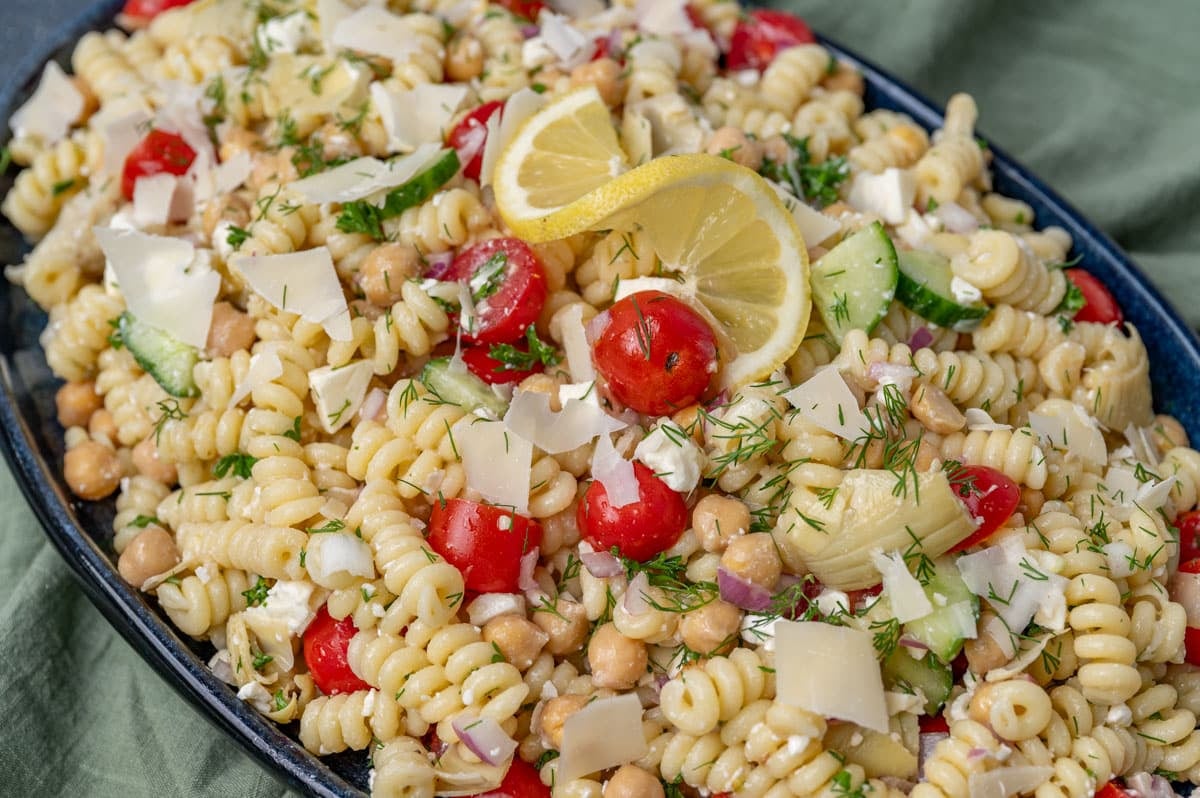 a plate of chickpea pasta salad with a lemon on top