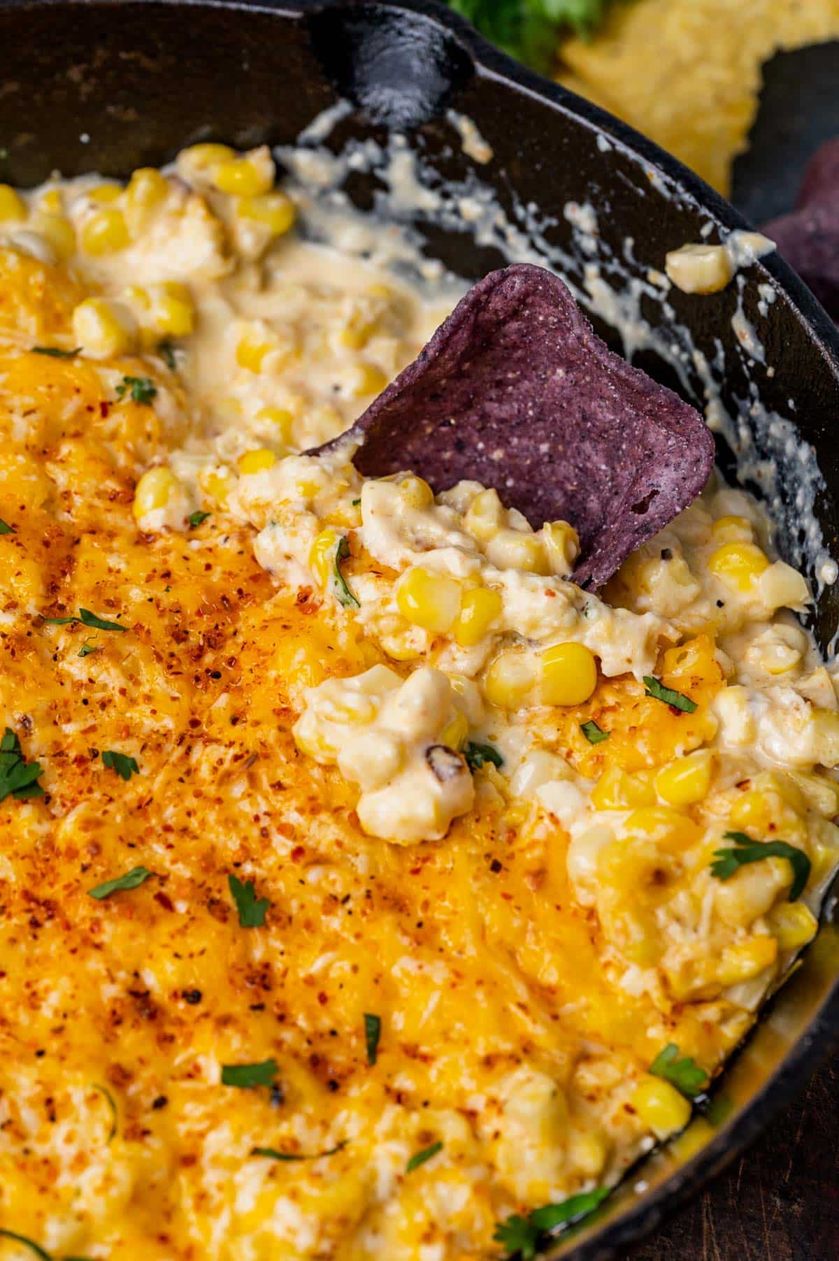 creamy mexican street corn dip in a skillet with tortilla chips