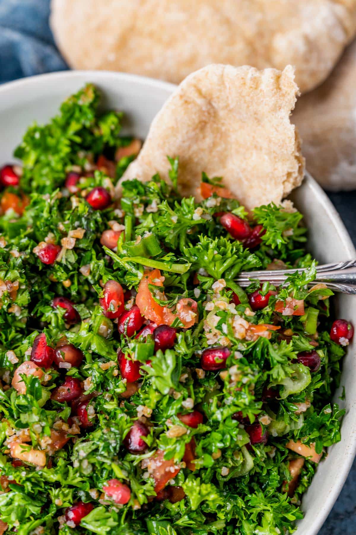 parsley salad in a bowl with pita bread