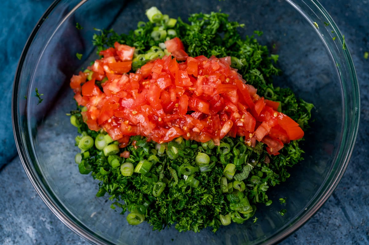 tomato, green onion and parsley in a glass bowl