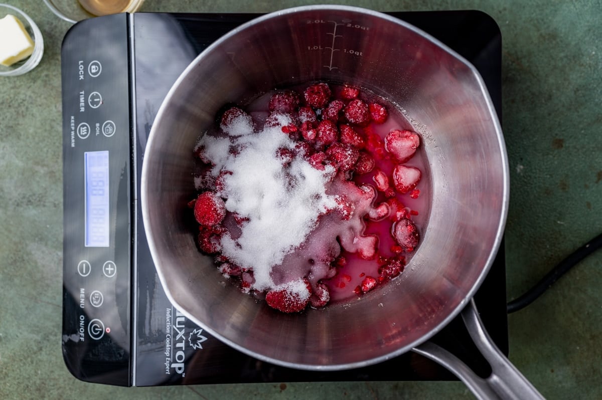 sugar, water and raspberries in a saucepan