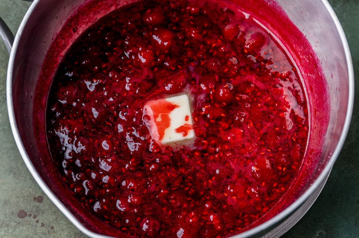 butter melting in raspberry sauce in a pan