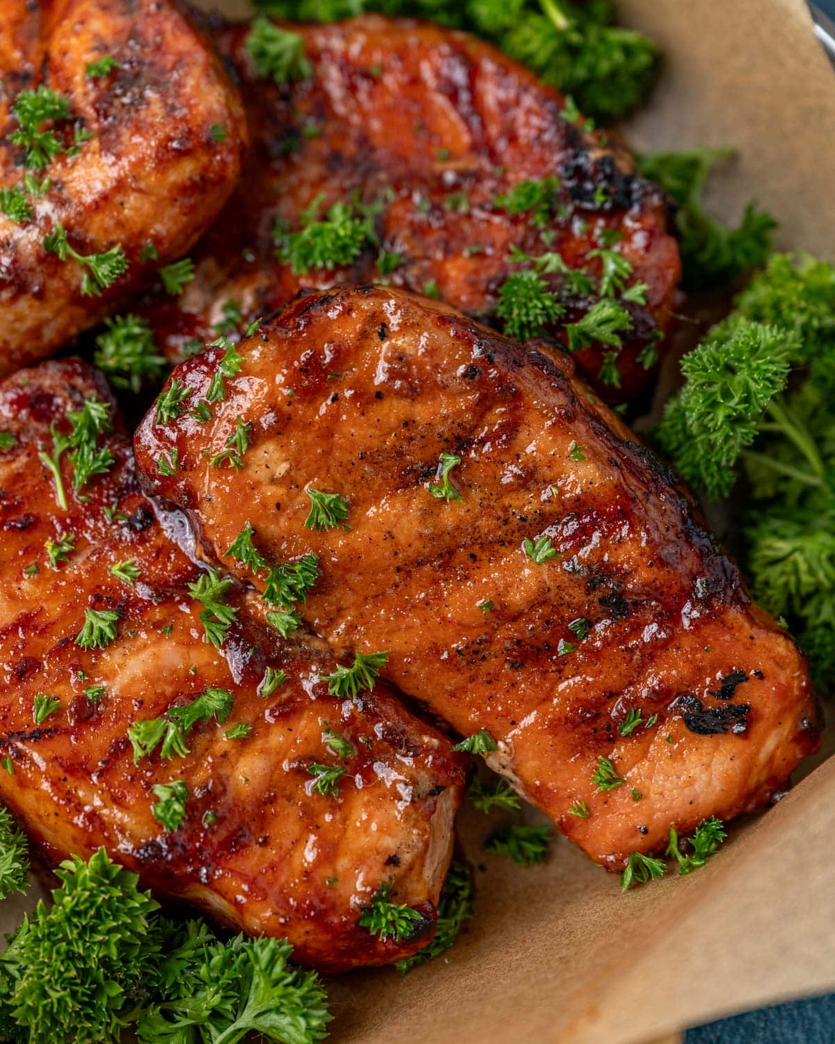 overhead view of grilled pork chops with bbq sauce and parsley