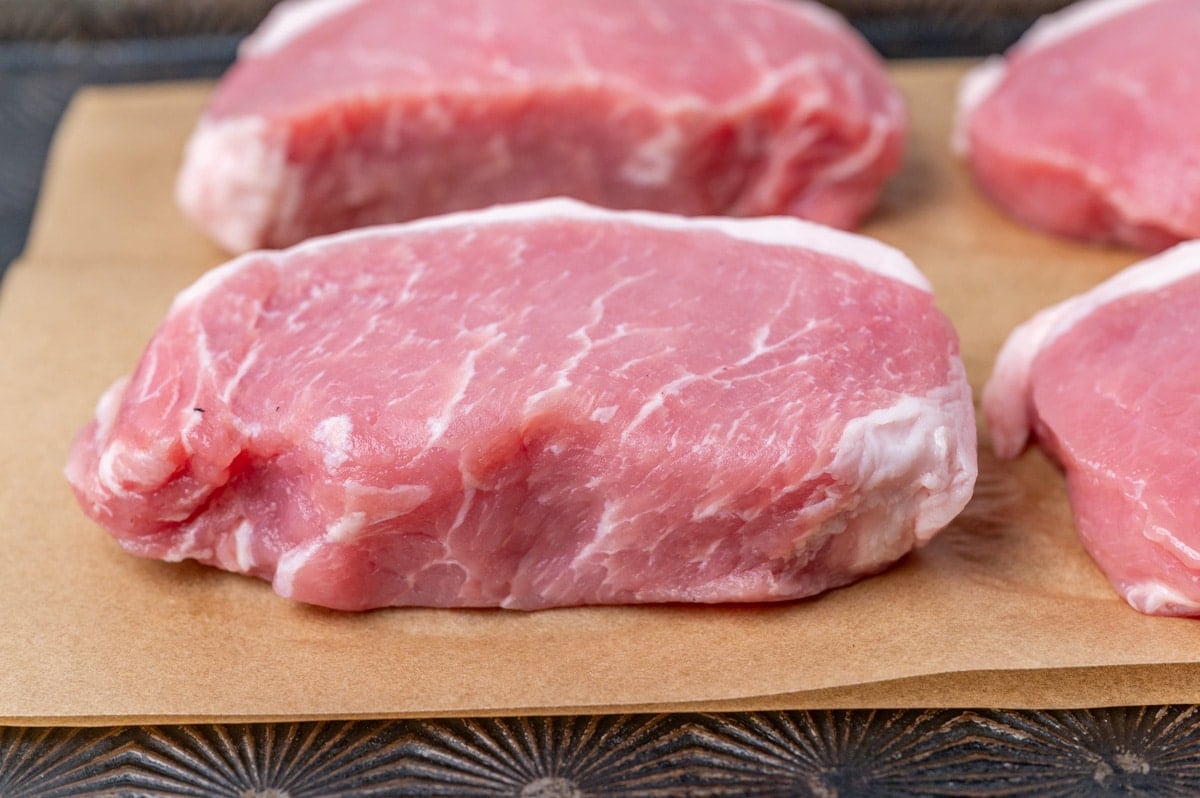 thick pork chops sitting on parchment paper