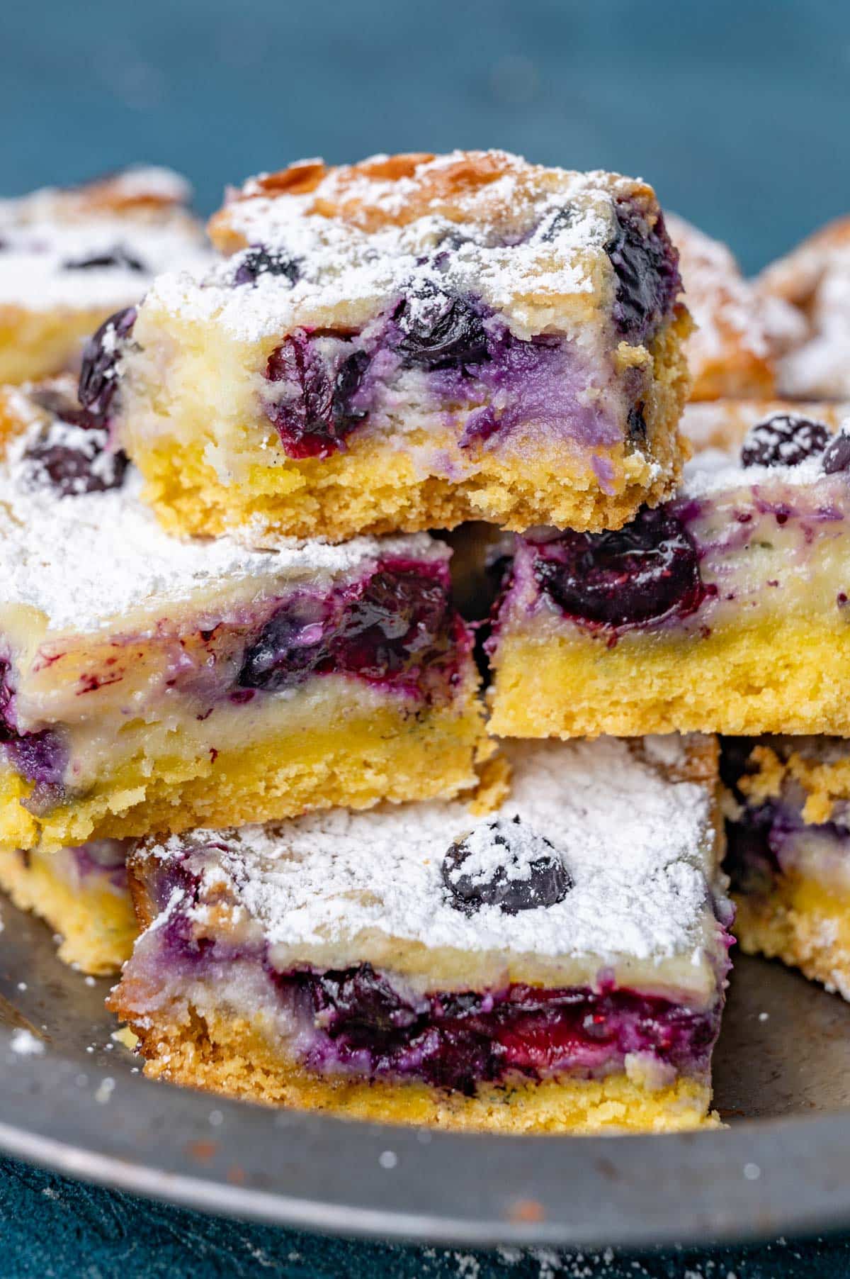 a plate of blueberry lemon gooey butter cake on a table