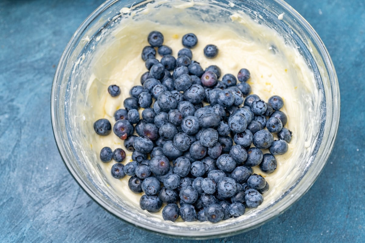 blueberries in cheesecake batter in a glass bowl