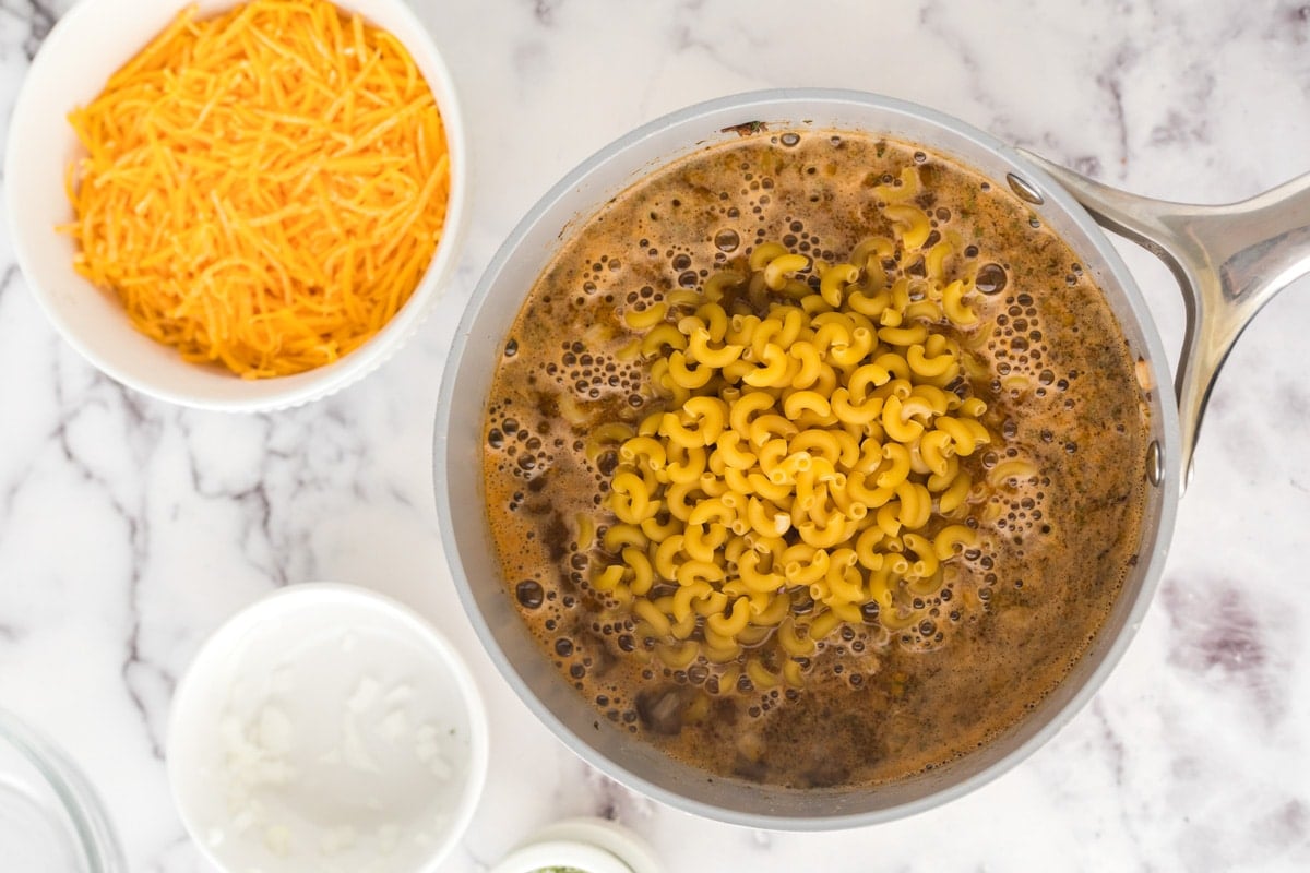 chicken broth and elbow macaroni in a skillet