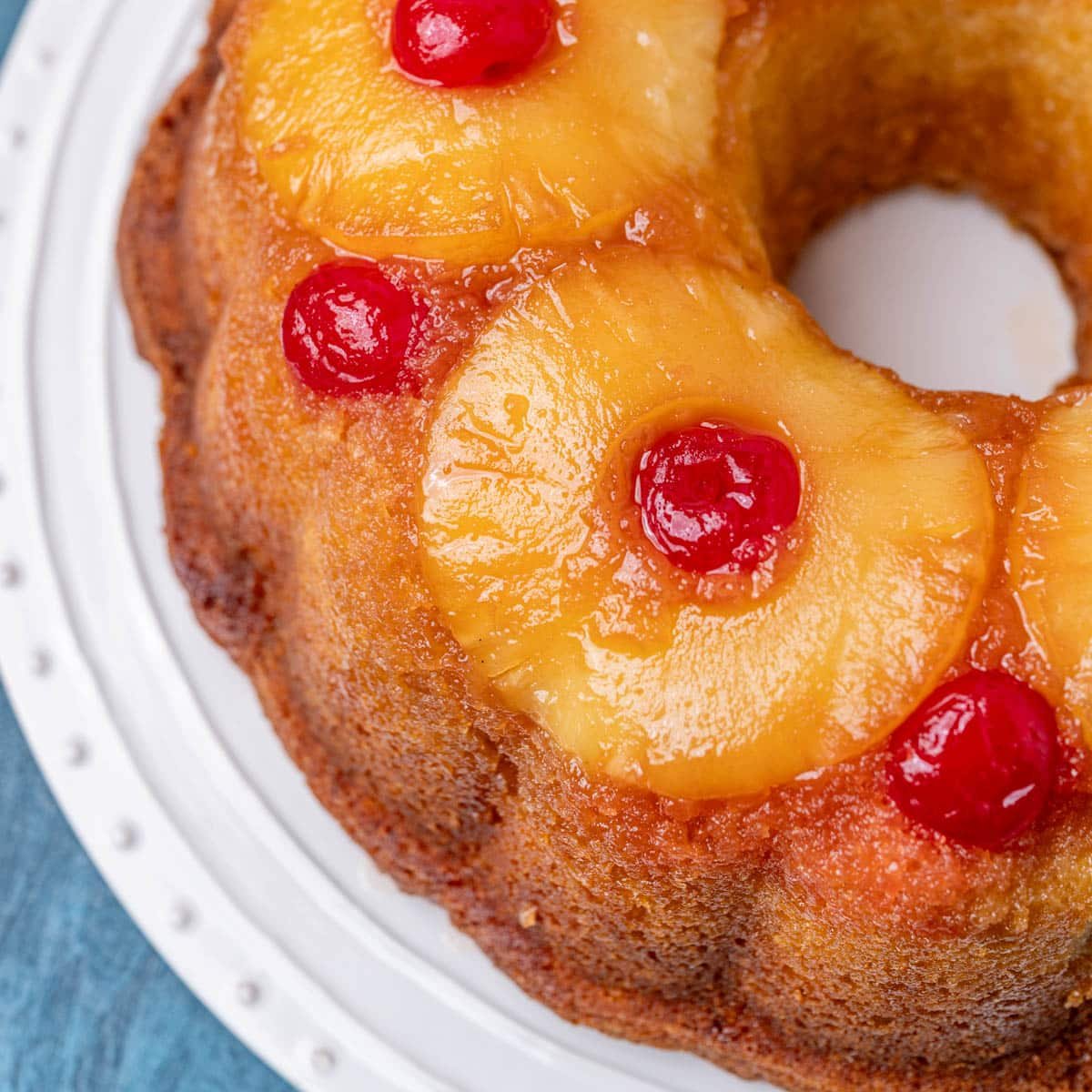 a bundt cake with pineapple rings and cherries on top