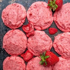 frosted strawberry cookies on a baking sheet