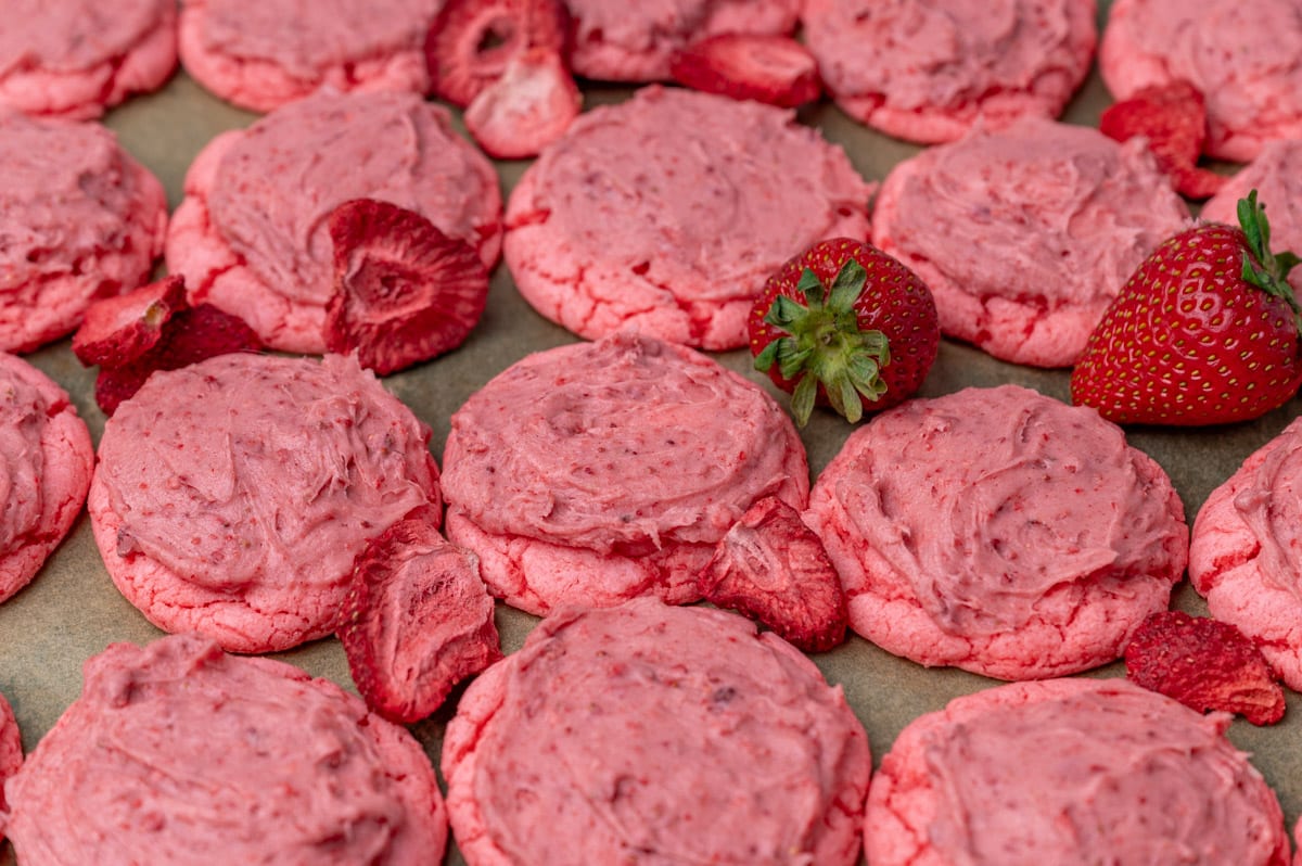 soft strawberry cookies with frosting on parchment paper