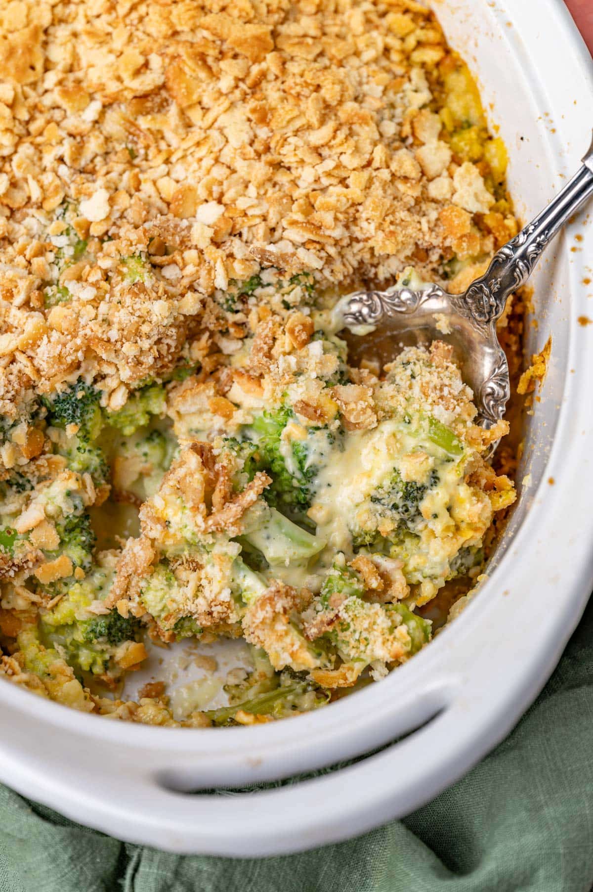 creamy broccoli casserole in a baking dish with a spoon