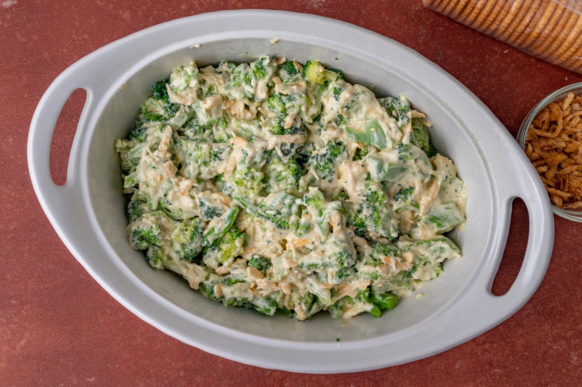 uncooked broccoli casserole in a white baking dish