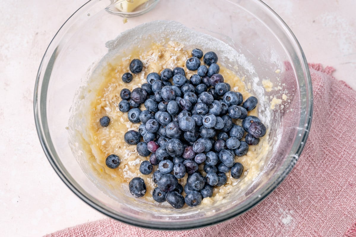 blueberries over bread batter in a bowl