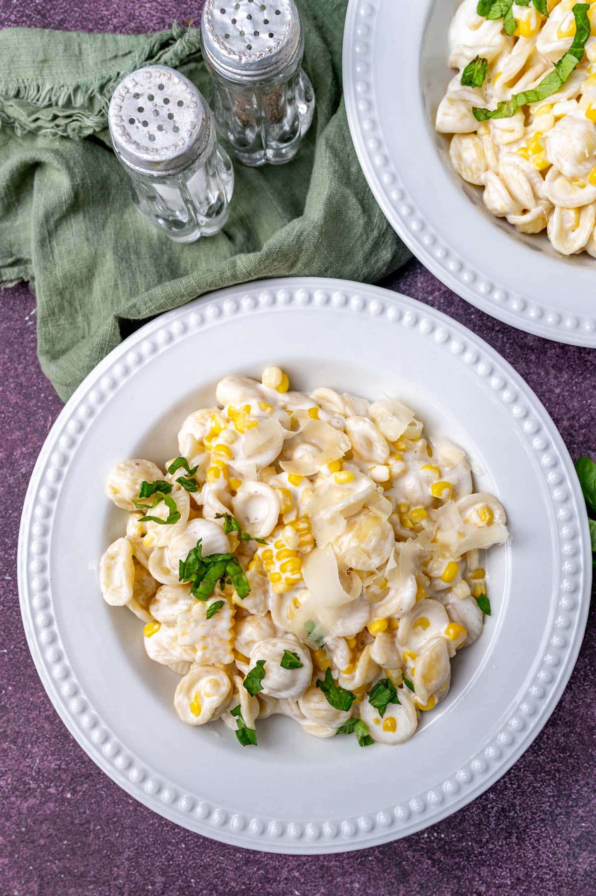 two plates of sweetcorn pasta on a table