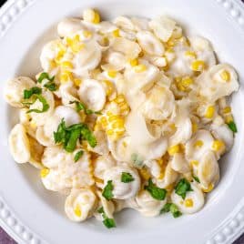 a plate of creamy corn pasta with parmesan and basil