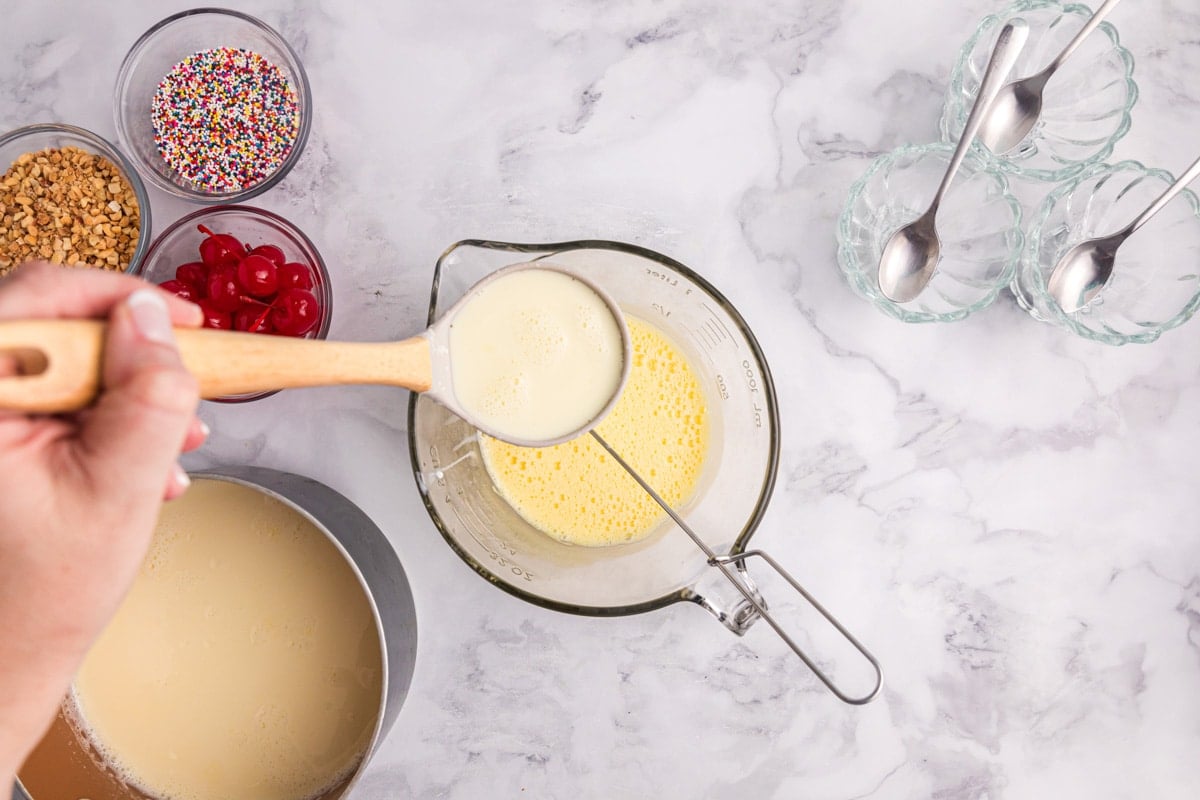 spooning hot milk into egg mixture